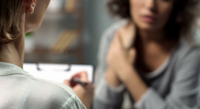 Female psychologist listening to young lady during personal session, depression